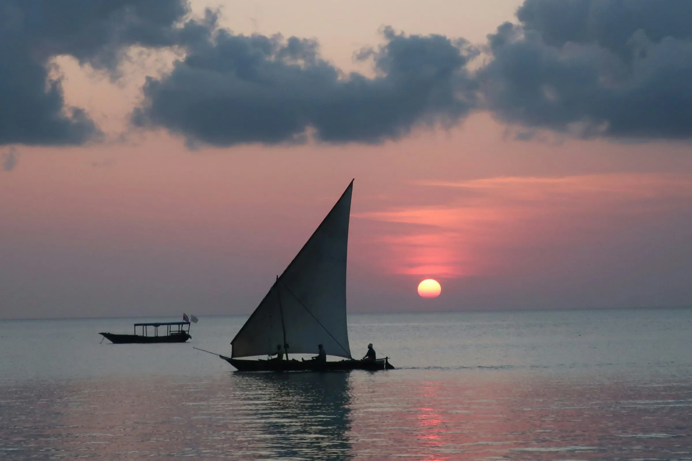 A traditional dhow sailing at sunset off the coast of Zanzibar